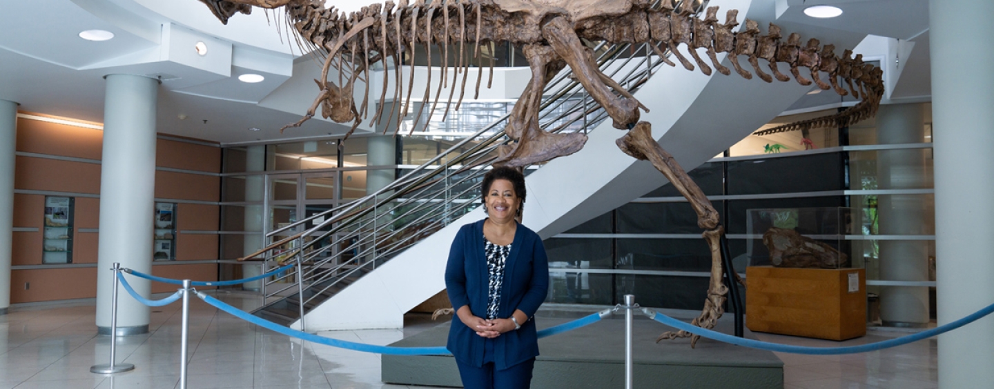Lisa D. White standing in front of a t-rex skeleton